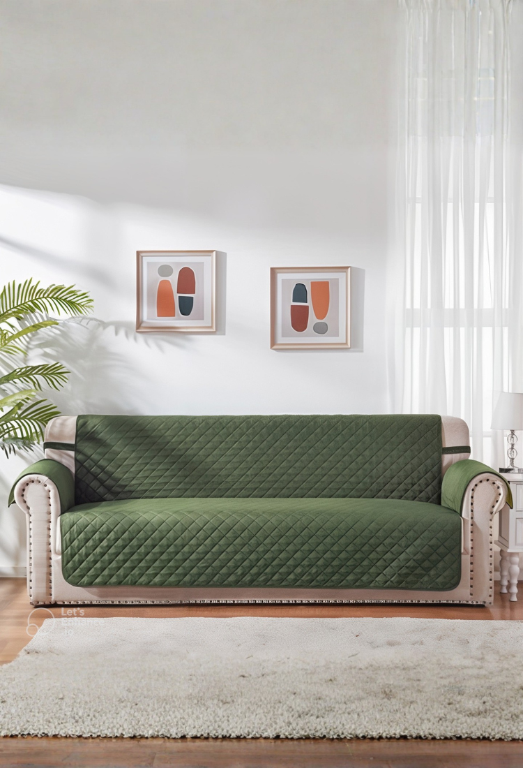 Green sofa cover on a couch in a living room with decor elements.